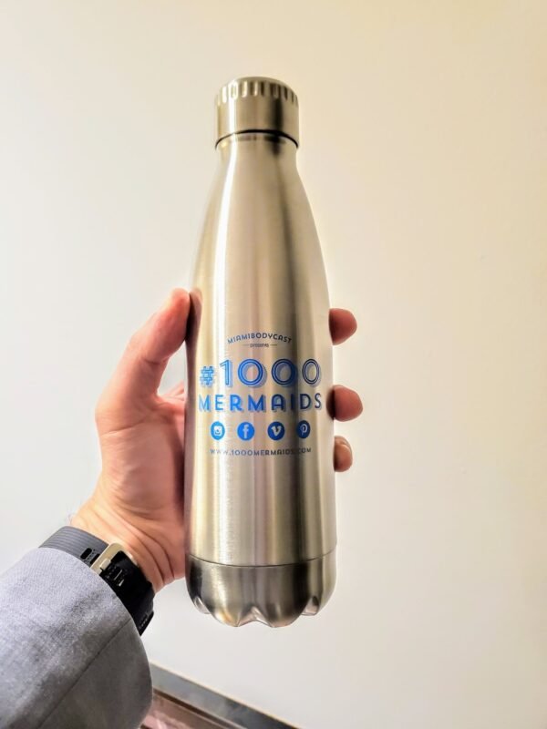 A shiny 16oz metal water bottle with the 1000 mermaids project logo on it